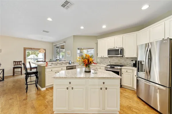 a kitchen with white cabinets and stainless steel appliances