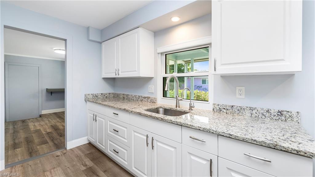 54 Hilo Court, Unit 54 Naples, FL 34112 - Photo 10 of 42 a kitchen with granite countertop white cabinets and a window