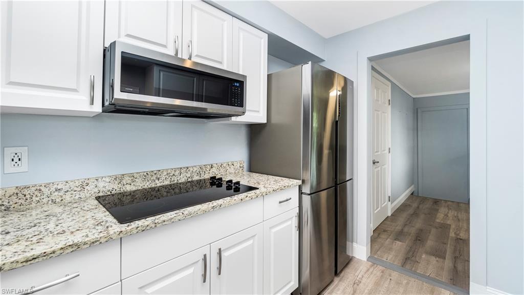 54 Hilo Court, Unit 54 Naples, FL 34112 - Photo 12 of 42 a kitchen with granite countertop a sink stove and refrigerator