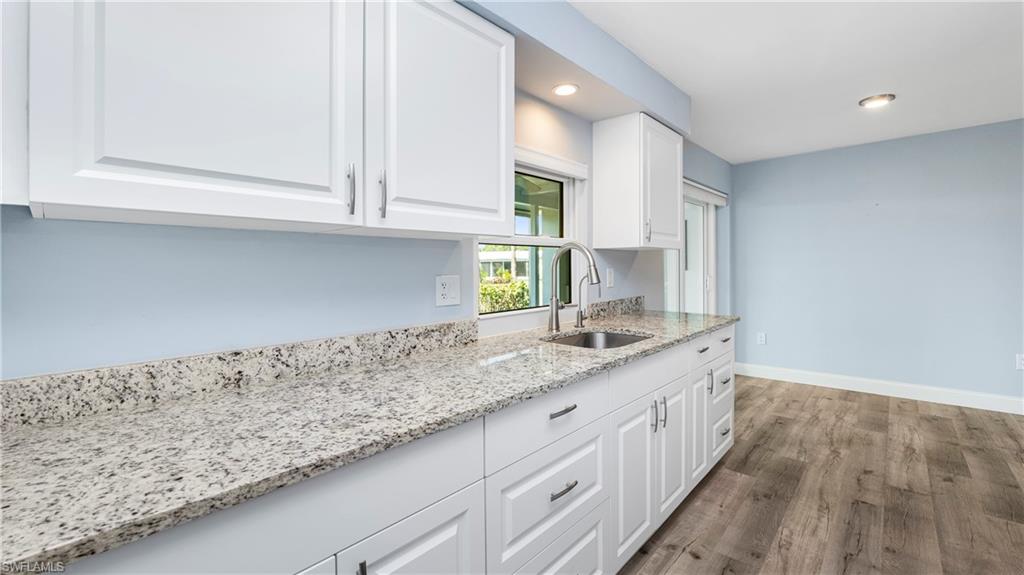54 Hilo Court, Unit 54 Naples, FL 34112 - Photo 13 of 42 a kitchen with granite countertop white cabinets and a sink