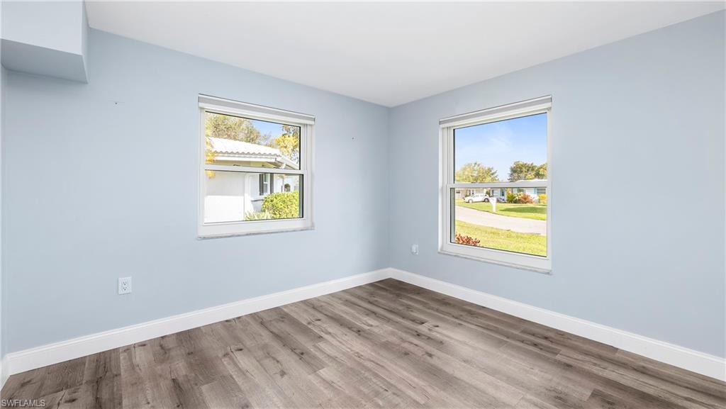 54 Hilo Court, Unit 54 Naples, FL 34112 - Photo 15 of 42 a view of an empty room with a window and wooden floor