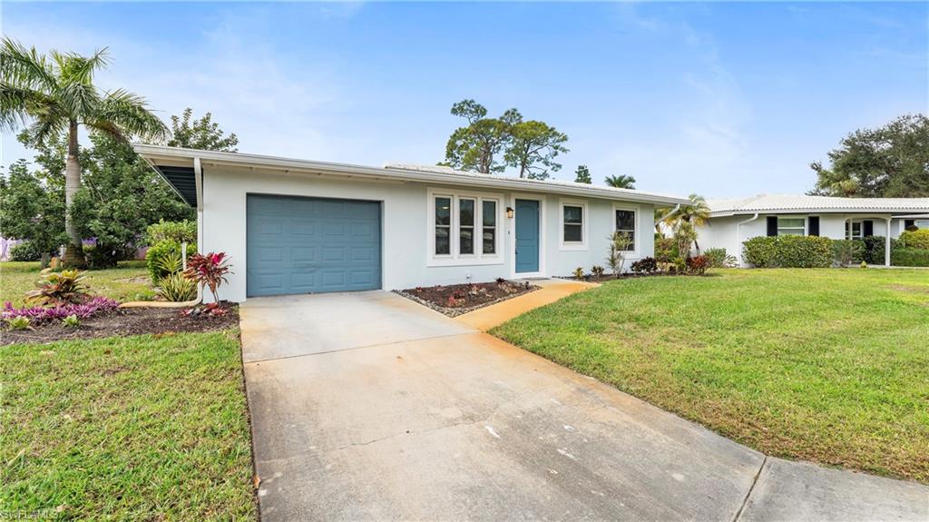 54 Hilo Court, Unit 54 Naples, FL 34112 - Photo 2 of 42 a front view of house with yard and green space