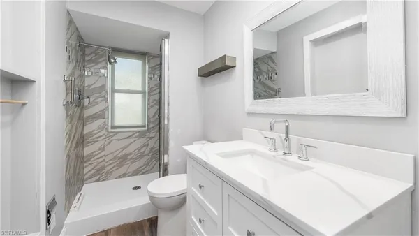 a bathroom with a granite countertop sink toilet and shower