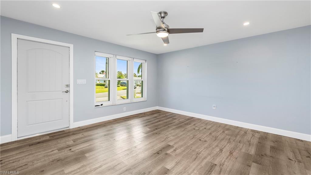 54 Hilo Court, Unit 54 Naples, FL 34112 - Photo 5 of 42 wooden floor in an empty room with a window