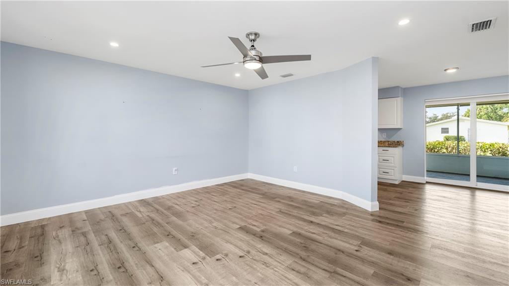 54 Hilo Court, Unit 54 Naples, FL 34112 - Photo 6 of 42 an empty room with wooden floor and windows