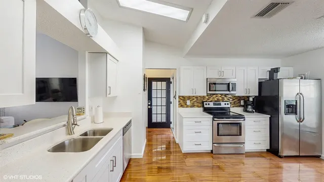 a kitchen with stainless steel appliances kitchen island granite countertop a refrigerator stove and sink