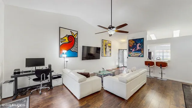 a living room with furniture kitchen view and a flat screen tv