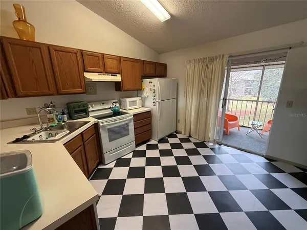 a kitchen with a checkered floor and white cabinets