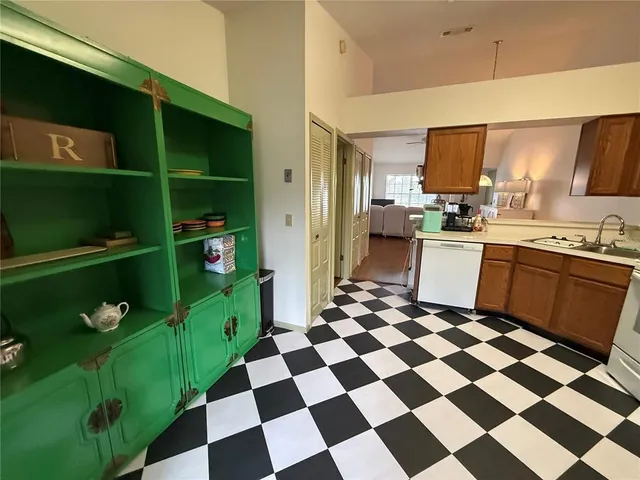 a kitchen with a checkered floor and white cabinets