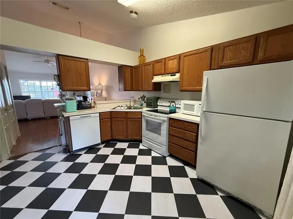 a kitchen with stainless steel appliances a stove a sink a refrigerator a microwave and cabinets