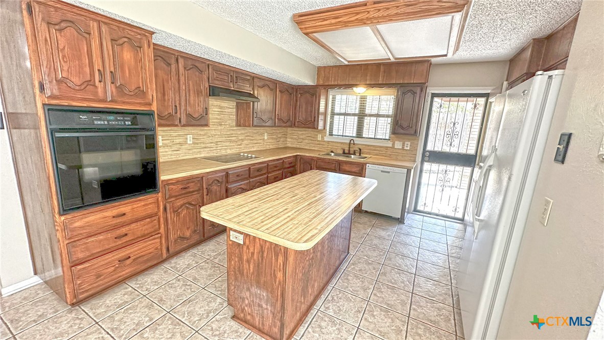 1500 Halbert Street Killeen, TX 76541 - Photo 15 of 36 a kitchen with granite countertop a stove a sink and a refrigerator