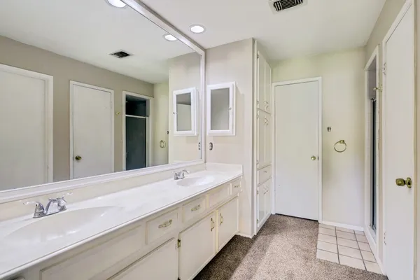 a spacious bathroom with double vanity and mirrors