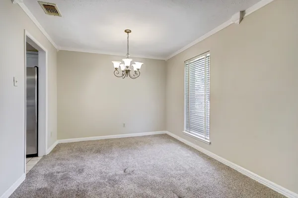 en empty room with windows and chandelier