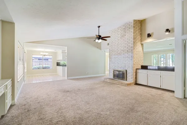 a view of a hallway with a kitchen and a fireplace
