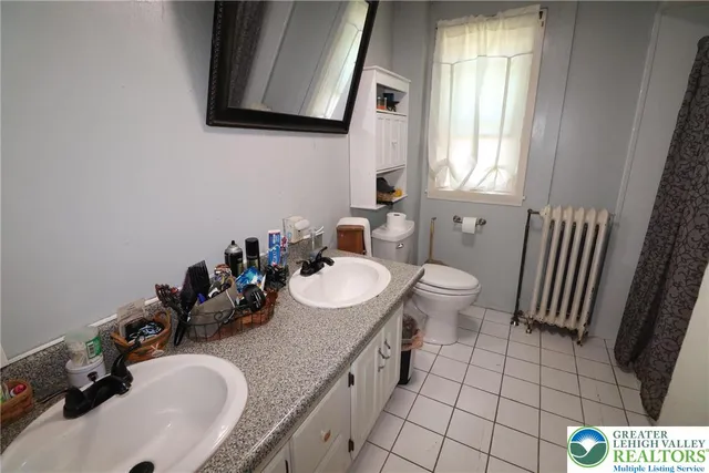 a bathroom with a sink toilet and mirror