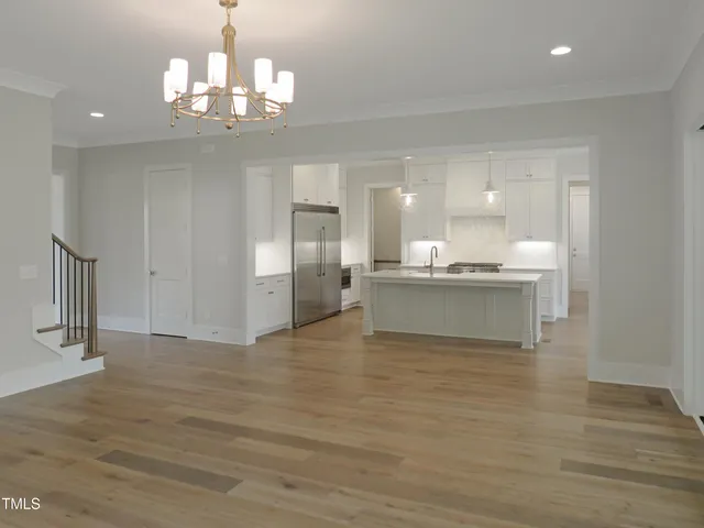 a view of a kitchen with a sink dishwasher wooden cabinet and a large mirror