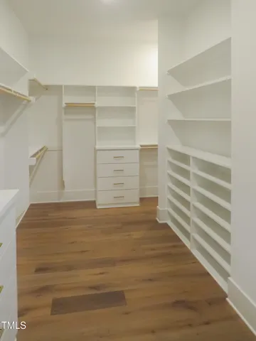a view of walk in closet with empty racks