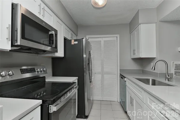 a kitchen with stainless steel appliances granite countertop a sink stove and microwave