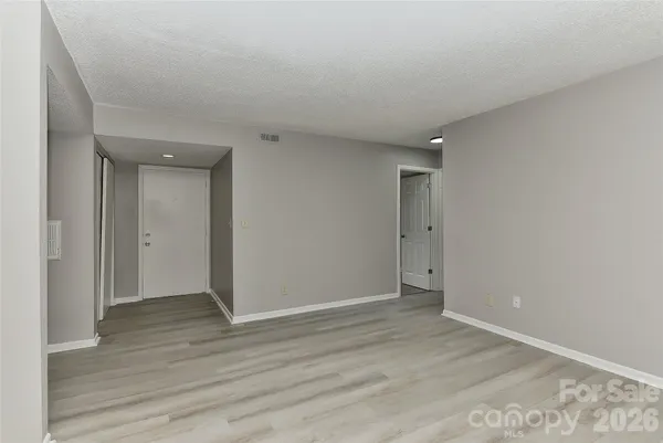 a view of an empty room with wooden floor