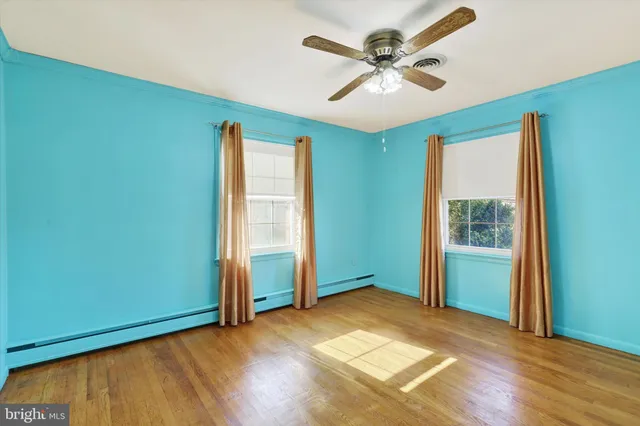 an empty room with a window and a ceiling fan