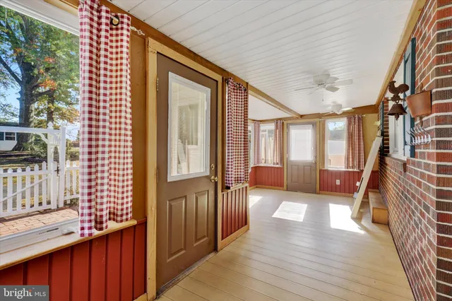 a view of a porch with wooden floor and furniture