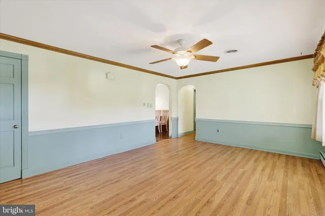 a view of a big room with wooden floor and windows