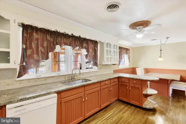 a kitchen with a sink cabinets and wooden floor