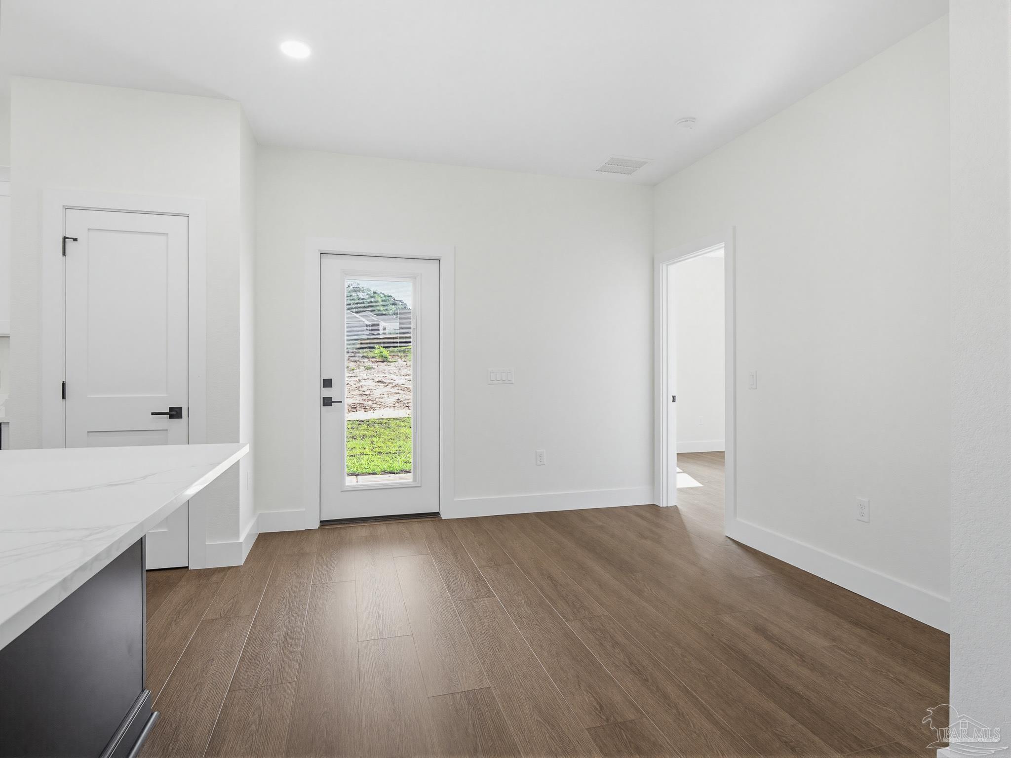 5724 Riviera Drive Milton, FL 32583 - Photo 23 of 52 a view of an empty room with a window and wooden floor