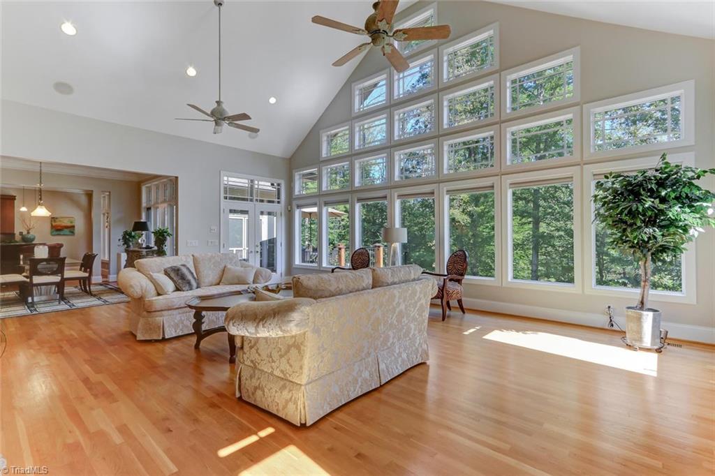 5260 Bunch Road Summerfield, NC 27358 - Photo 11 of 30 Another view of the Great Room showing the beautiful wall of windows and the views beyond. French door to deck has transoms above.