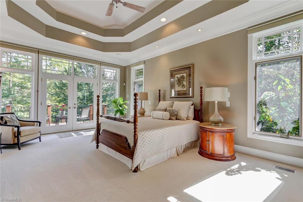 5260 Bunch Road Summerfield, NC 27358 - Photo 13 of 30 The Master Bedroom Suite has wall to wall carpeting, large windows, French doors to a private deck, and has ample room for a sitting area. Double tray ceiling with cove lighting, recessed lighting, and ceiling fan. The corner location provides ample natural light.
