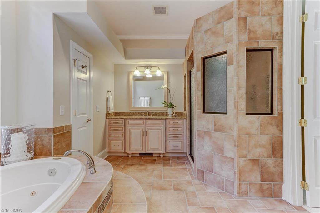5260 Bunch Road Summerfield, NC 27358 - Photo 14 of 30 The Master Bath features a large jetted tub, double vanities, granite countertops, large walk-in shower. Tile flooring. The suite has two walk-in closets.