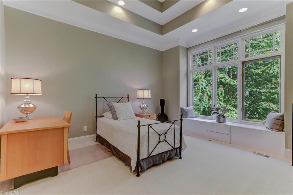 5260 Bunch Road Summerfield, NC 27358 - Photo 17 of 30 Bedroom 3 on the main level has carpeted floor, recessed ceiling lights, double tray ceiling, built-in window seat with storage and features and en-suite bath.