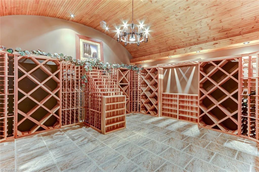 5260 Bunch Road Summerfield, NC 27358 - Photo 21 of 30 Wood detailed barrel vaulted ceiling with recessed lighting and central chandelier create a stunning backdrop to this 2,700+ bottle wine cellar. Plenty of space for a tasting table and chairs.