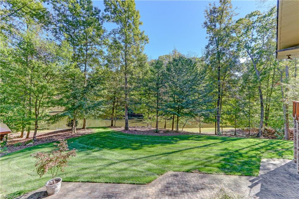 5260 Bunch Road Summerfield, NC 27358 - Photo 28 of 30 Another view of the beautifully kept patio and grounds gently rolling down to the pond.
