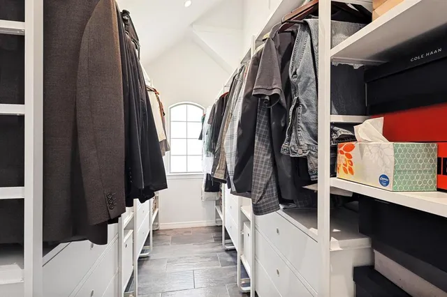 a view of walk in closet with clothes and shoes