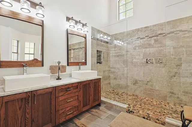 a bathroom with a double vanity sink mirror and shower