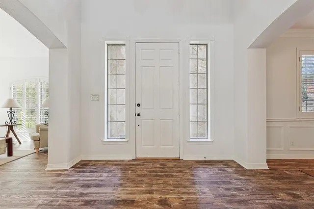 a view of an empty room with window and wooden floor