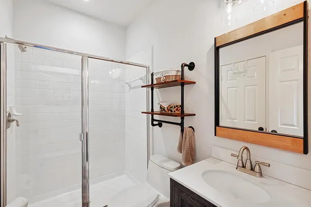 a bathroom with a shower sink and mirror