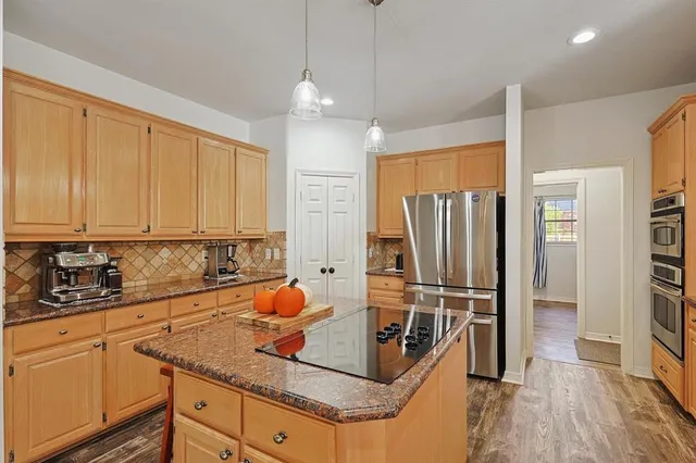 a kitchen with stainless steel appliances granite countertop a sink refrigerator and cabinets