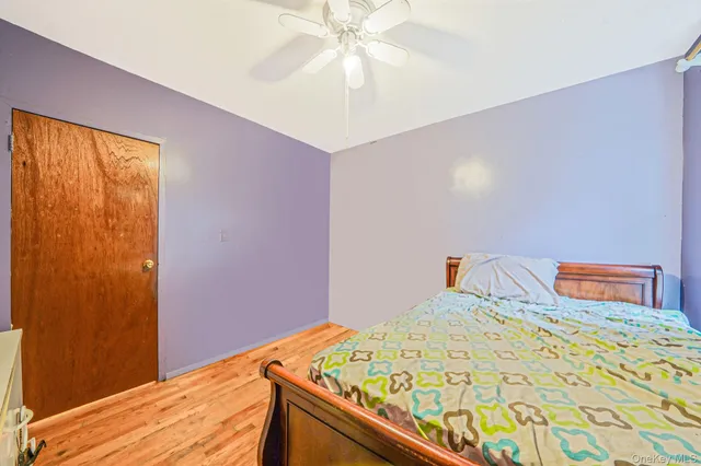 a bedroom with a bed and a chandelier fan