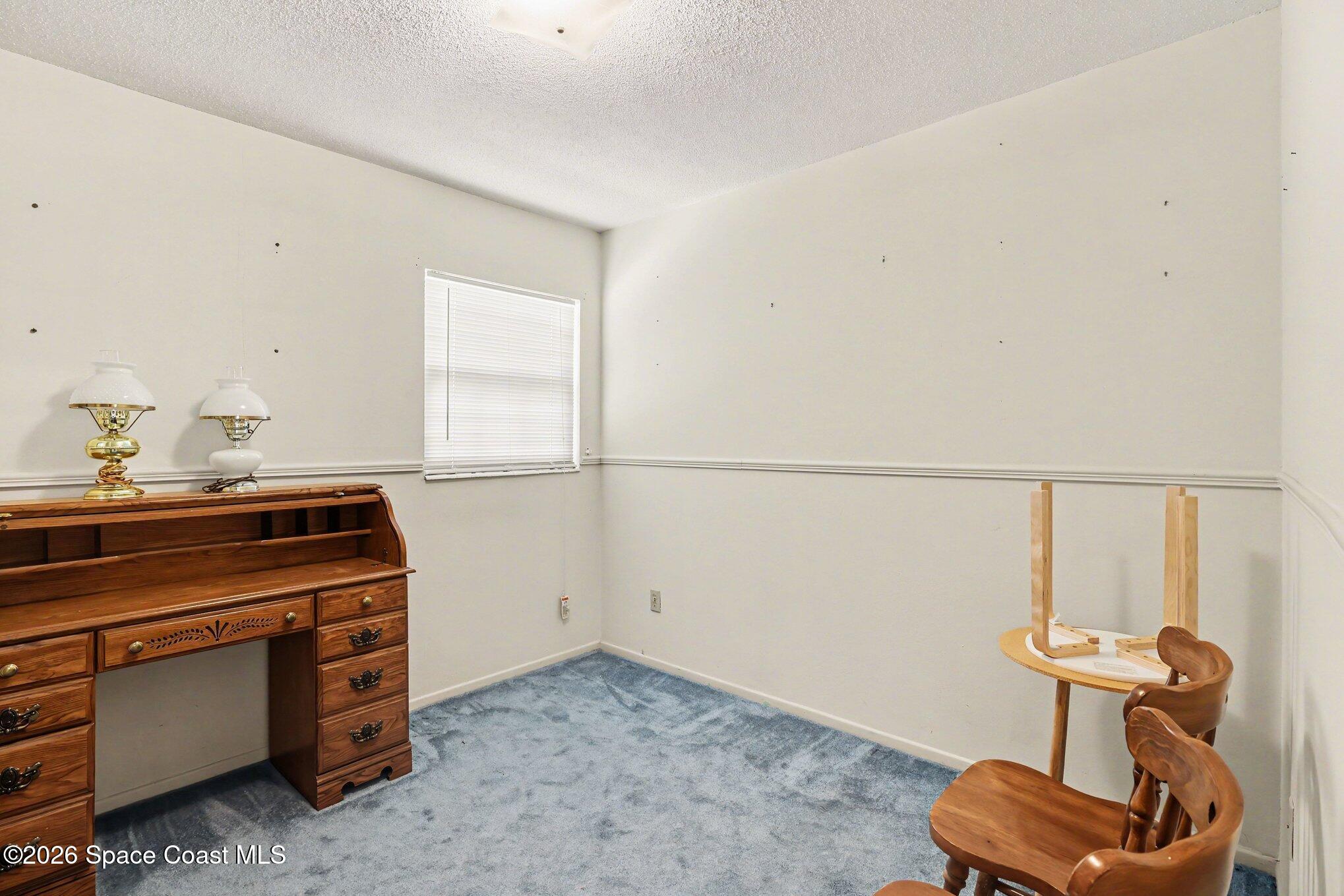 979 Kings Post Road Rockledge, FL 32955 - Photo 11 of 15 a room with a chair and white walls