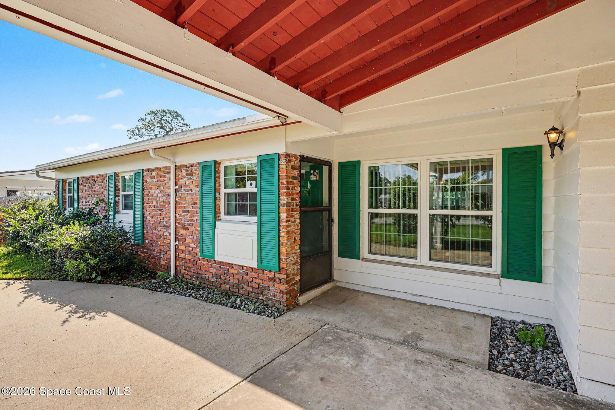 979 Kings Post Road Rockledge, FL 32955 - Photo 2 of 15 a front view of a house with a large window and potted plants