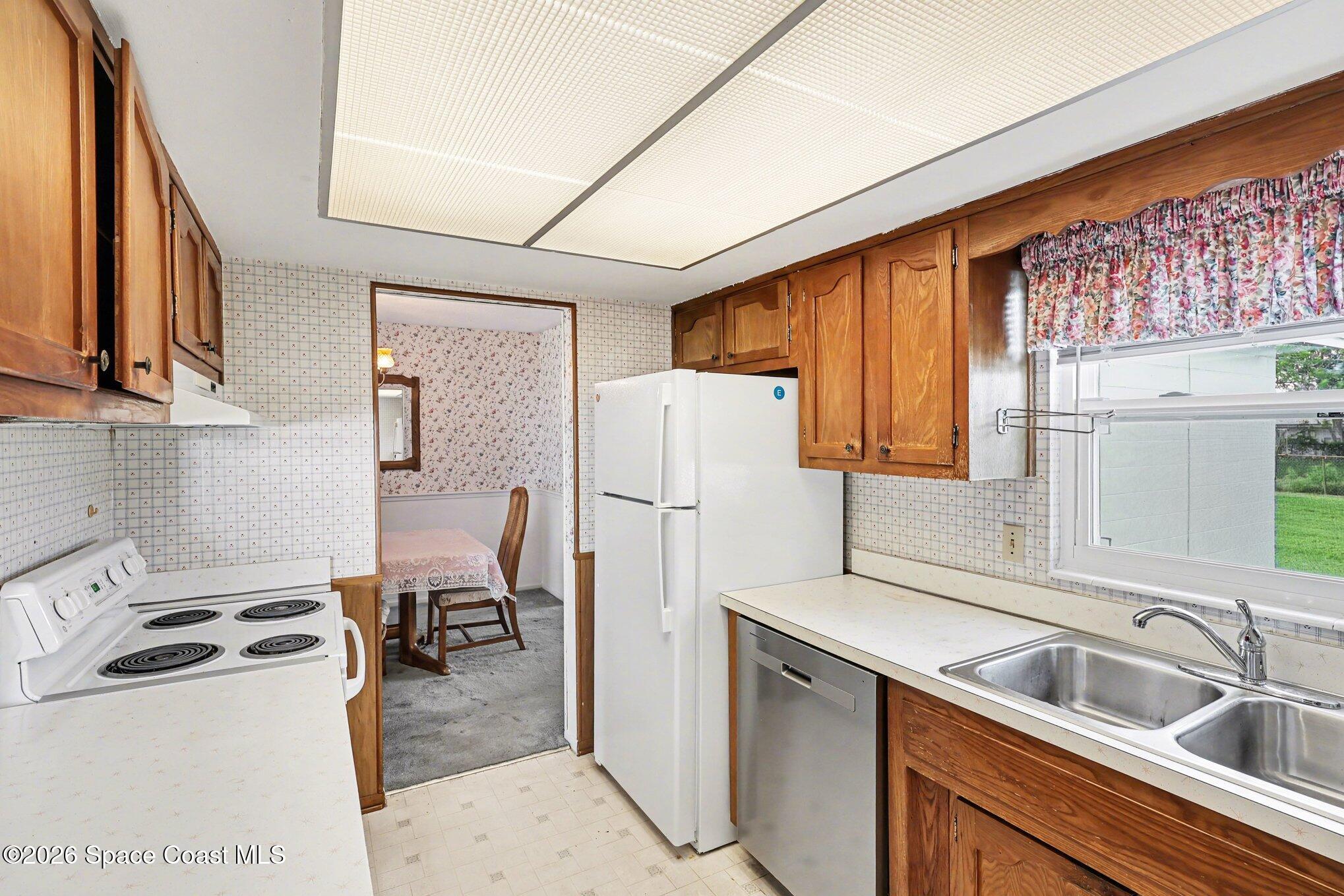 979 Kings Post Road Rockledge, FL 32955 - Photo 6 of 15 a kitchen with a sink a refrigerator and cabinets