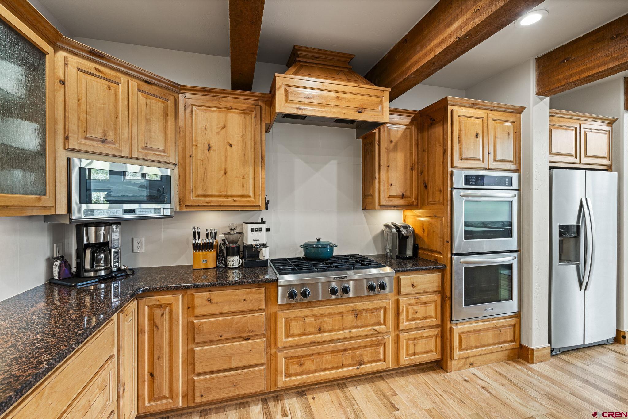 95 Turnberry Drive Durango, CO 81301 - Photo 6 of 36 a kitchen with stainless steel appliances granite countertop a refrigerator a stove and a sink with wooden floor