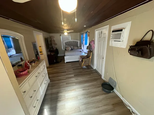 a hallway with white cabinets and wooden floor