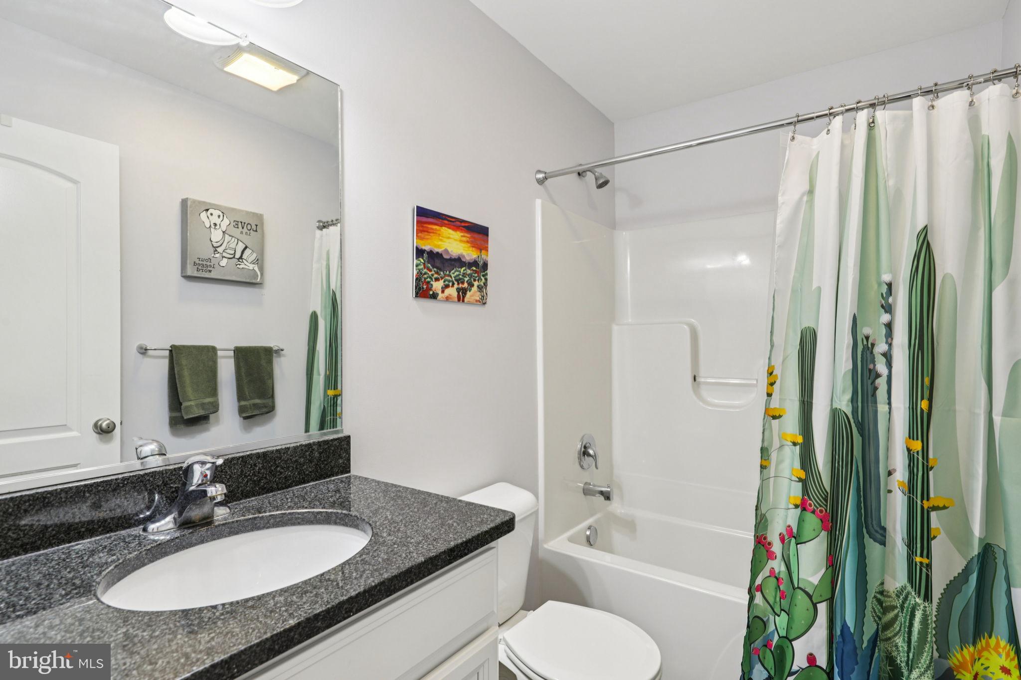 268 Shannon Court Inwood, WV 25428 - Photo 14 of 26 a bathroom with a granite countertop sink toilet a mirror a bathtub and shower