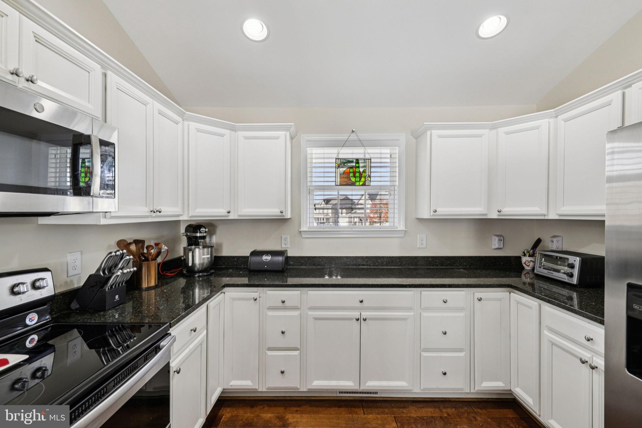 268 Shannon Court Inwood, WV 25428 - Photo 10 of 26 a kitchen with granite countertop white cabinets and black appliances