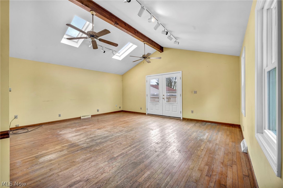 1011 Spring Road Cleveland, OH 44109 - Photo 23 of 47 Unfurnished room with lofted ceiling with skylight, light hardwood / wood-style flooring, a healthy amount of sunlight, and rail lighting