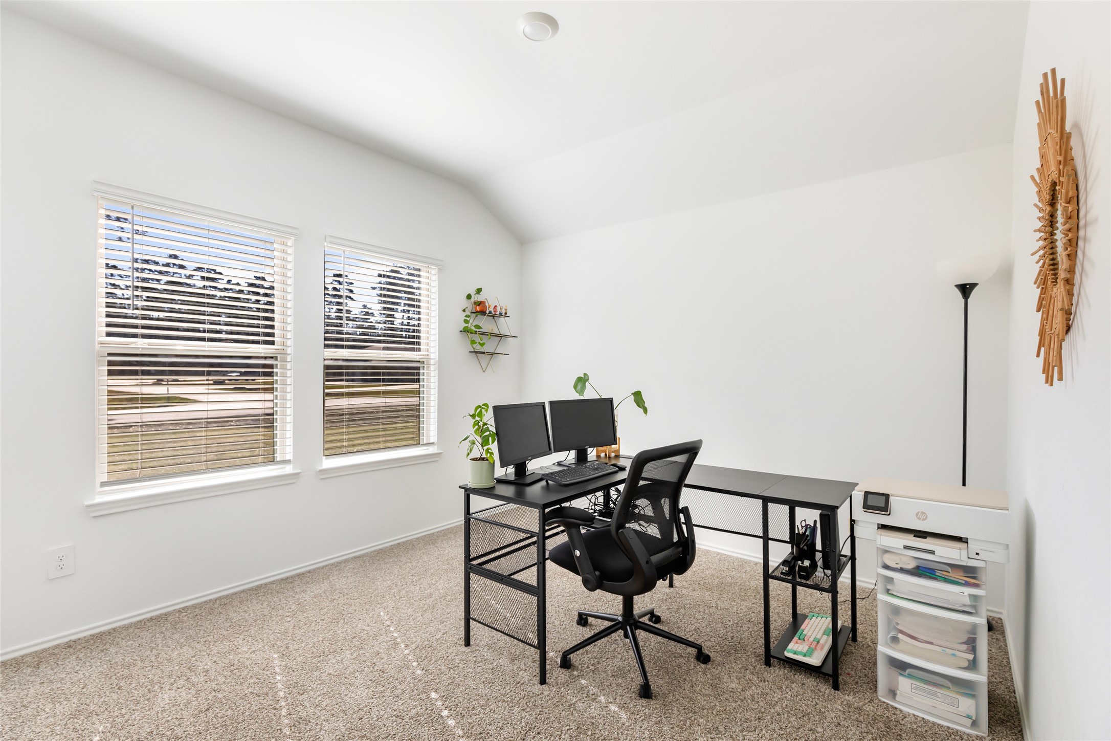 811 Republic Road New Caney, TX 77357 - Photo 16 of 37 This room is a bright, minimalist home office featuring a large window with blinds, a simple desk setup with a computer and office chair, carpeted flooring, and a few decorative plants. Ideal for productivity and comfort.