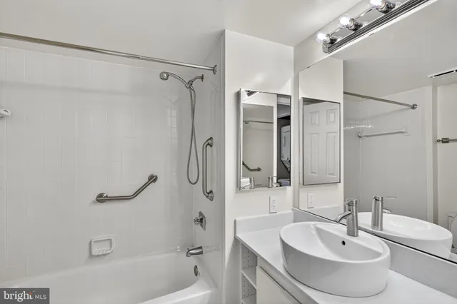 a bathroom with a sink mirror and shower